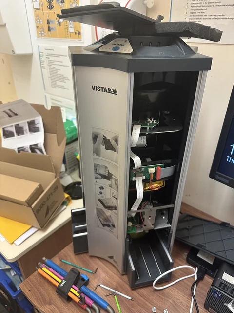 Intraoral imaging plate scanner with its housing open and internal components visible.