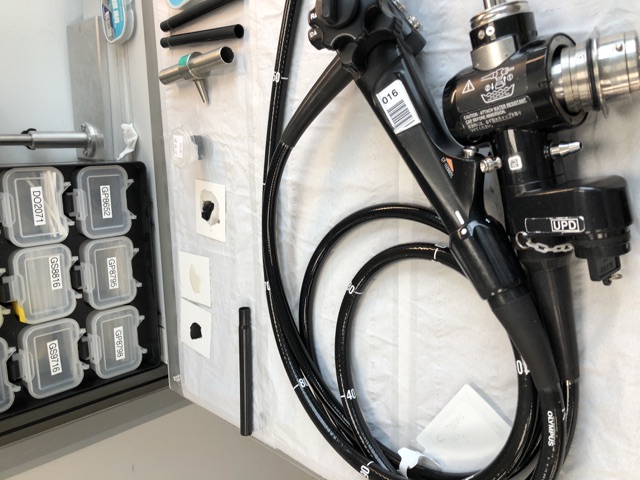 Flexible endoscope with its control section, connector and coiled insertion tube on a worktop.