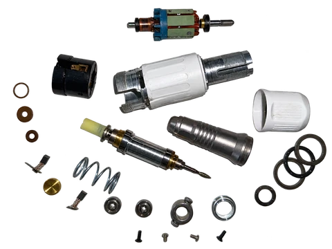Disassembled micromotor handpiece with its rotor, shaft, housings, bearings, brushes and spring.